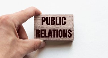 Tahta bloklar tutan bir işadamının eli. Kavramsal görüntü. Metin PUBLIC İlişkiler konsept işi başarılı.