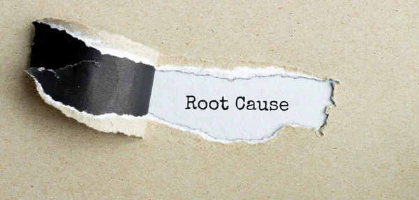 The text Root Cause appearing behind torn brown paper