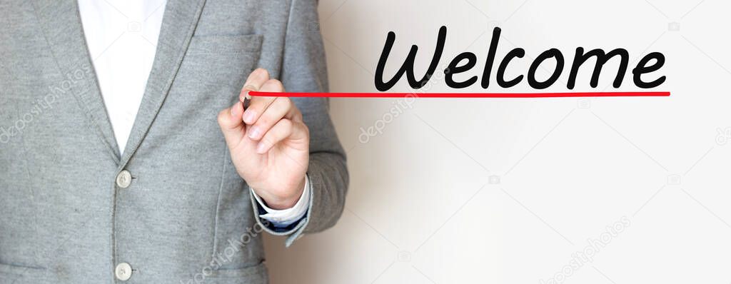 Businessman wriring text WELCOME with marker, business concept