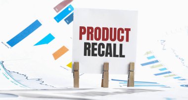 ProDUCT RECall metin üzerinde kağıt kağıt kağıt tabaka, zarlar, gözlük, kalem, dizüstü bilgisayar ve mavi ve sarı itme pin ahşap masa - işletme, bankacılık, finans ve yatırım konsepti