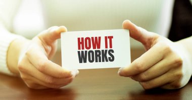 İş kadını elinde nasıl çalıştığını anlatan bir kart tutuyor.