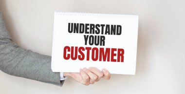 Elinde yazılı bir kart tutan bir adam. KUŞAĞINI İSTİYOR