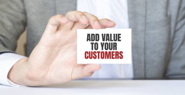 Elinde ADD VALUE yazan bir kart tutan adam.