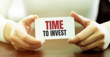 Kartvizitini gösteren iş kadını INVEST 'e mesaj zamanı, izole edilmiş beyaz arkaplan