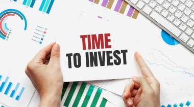 Klavye, diyagram ve beyaz arkaplan için mesaj zamanı içeren bir kart tutan işadamı