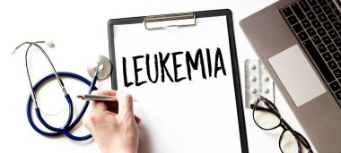 Doktorun eli kalem ve siyah kağıt tabakla LEUKEMIA kartı tıp doktorunun elinde.
