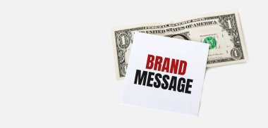 Beyaz arka planda 1 dolarlık banknot ve beyaz not kağıdı var. Damga Mesajı Metni.