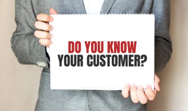 İşadamı elinde yazılı bir kart tutuyor. KÜTÜRÜNÜĞünü tanıyor musun?