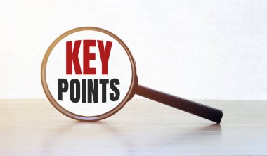 Ahşap masa üzerinde anahtar noktaları olan büyüteç.