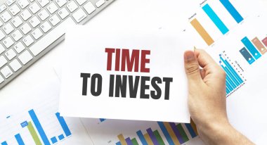 Klavye, diyagram ve beyaz arkaplan için mesaj zamanı içeren bir kart tutan işadamı