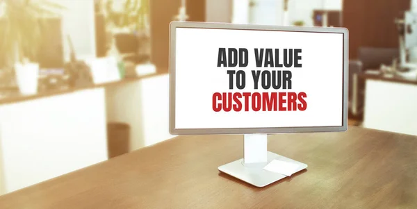 Monitor in modern office with ADD VALUE TO YOUR CUSTOMER text on the screen