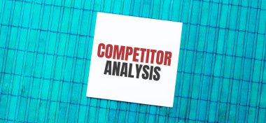 Yeşil ahşap zemin üzerinde COMPETITOR ANALYSIS metin ile boş not defteri