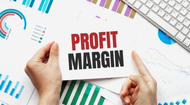 Boş çarşaf, kalem ve buruşuk kağıt toplar gri masada, düz yatıyordu. Kâr Marjinali