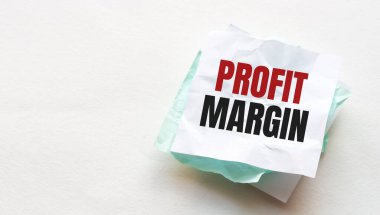 Tahta masadaki defter ve kalem, metin için kopyalama alanı, buruşuk sarı kağıt üzerinde kadın el yazısı PROFIT MARGIN, çalışma yeri, beyin fırtınası