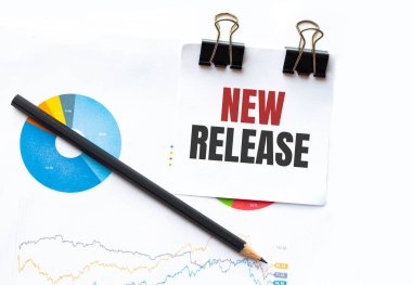 Çalışma grafikleri ve kalemler üzerinde NEW RELEASE metin ile not