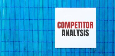 Yeşil ahşap zemin üzerinde COMPETITOR ANALYSIS metin ile boş not defteri