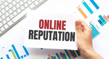 İş adamı ONLINE Klavye, diyagram ve beyaz arkaplan içeren bir kart tutuyor