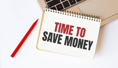 Dizüstü bilgisayar, kırmızı kalem ve beyaz arka planda para biriktirmek için mesaj zamanı olan not defteri.