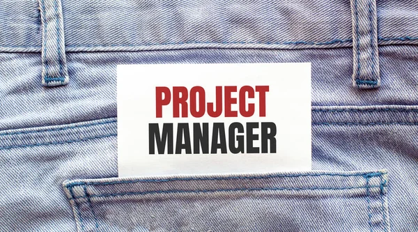 PROJECT MANAGER words on a white paper stuck out from jeans pocket. Business concept