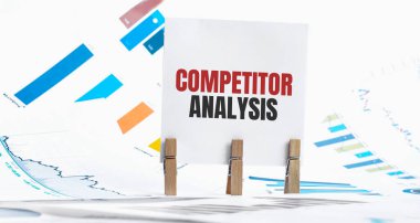 KOMPETITOR ANALYSIS metin üzerinde kağıt kağıt kağıt kağıt kağıt, zar, gözlük, kalem, dizüstü bilgisayar ve mavi ve sarı itme pin ahşap masa üzerinde - işletme, bankacılık, finans ve yatırım konsepti