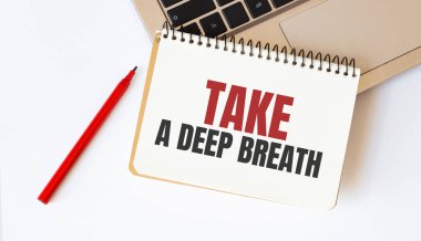 Yazılı dizüstü bilgisayar, kırmızı kalem ve not defteri beyaz arkaplanda derin bir nefes al