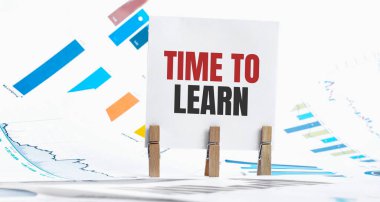 Çizelge, zar, gözlük, kalem, dizüstü bilgisayar ve mavi ve sarı broşlu metni ahşap masa - işletme, bankacılık, finans ve yatırım kavramlarıyla öğrenme zamanı