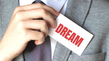 DREAM yazılı bir kart tutan işadamı