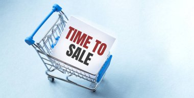 Alışveriş arabası ve Time to sell to white paper note list. Mavi arkaplanda alışveriş listesi kavramı.