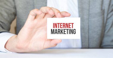 İşadamı elinde internetteki yazılı bir kart tutuyor.