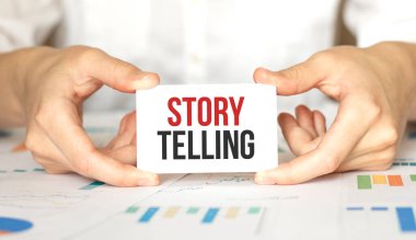 İş kadını elinde yazılı bir kart tutuyor. Hikaye anlatıyor.