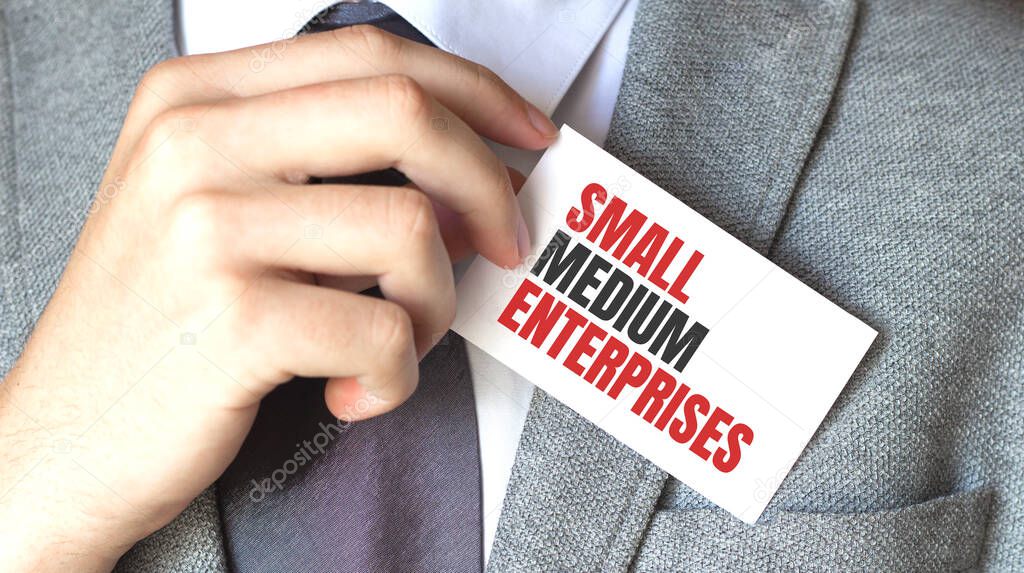 businessman holding a card with text SMALL MEDIUM ENTERPRISES