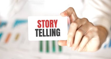 İş kadını elinde yazılı bir kart tutuyor. Hikaye anlatıyor.