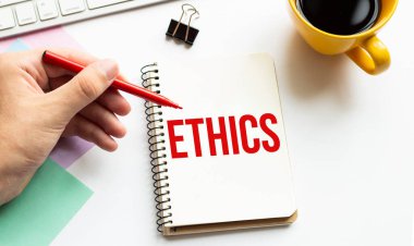 Kırmızı kalemle. Kahve fincanı. Kal. Klavye ve beyaz arka plan. Not defterinde ETHICS işareti