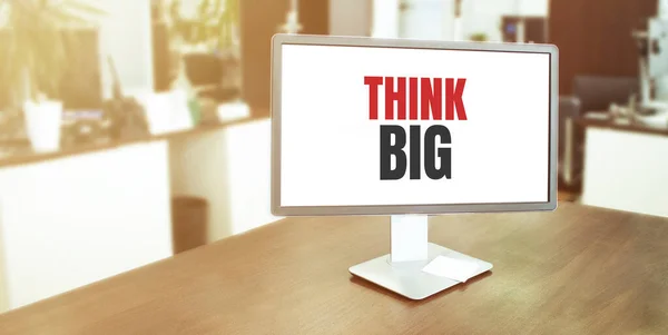 Monitor in modern office with THINK BIG text on the screen