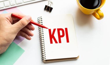 Kırmızı kalemle. Kahve fincanı. Kal. Klavye ve beyaz arka plan. Not defterinde KPI imzası