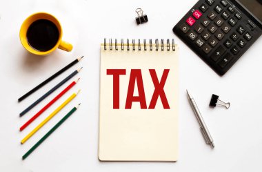 Kahve fincanı, hesap makinesi, not defteri, beyaz arka planda kalem ve kalemler. İş konsepti. Metin Vergisi