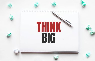 Boş çarşaf, kalem ve buruşuk kağıt toplar gri masada, düz yatıyordu. Metin Büyük Düşün