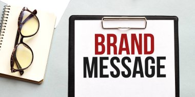 İş konsepti. Not defteri beyaz arka planda gözlük, notlar için beyaz kağıt metin BRAND MESSAGE sayfası