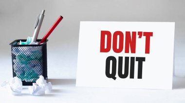 Boş çarşaf, kalem ve buruşuk kağıt toplar gri masada, düz yatıyordu. Metin Dönüşü Çık