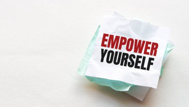 Tahta masaya defter ve kalem, metin için kopyalama alanı, buruşuk sarı kağıda EMPOWER yazan kadın el yazısı, iş yeri, beyin fırtınası