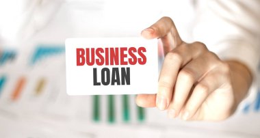 İş kadını elinde iş kredisiyle bir kart tutuyor.