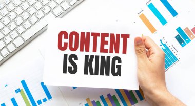 Elinde metin içeriği olan bir kart tutan iş adamı kraldır. Klavye, diyagram ve beyaz arkaplan.