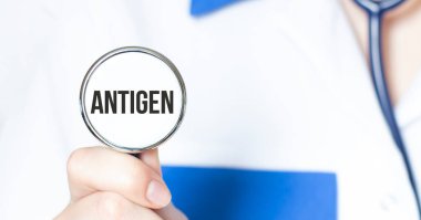 Doktorun elinde steteskop ve ANTIGEN yazılı tıbbi konsept var.