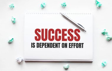 Boş çarşaf, kalem ve buruşuk kağıt toplar gri masada, düz yatıyordu. Metin Başarı çabaya bağlıdır