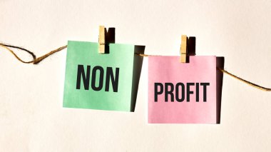 Beyaz duvardaki ya da masadaki sarı etiket üzerine NON PROFIT metin sözcükleri yazımı