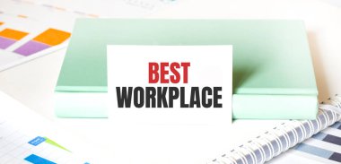 Beyaz büyük not defteri, yeşil kitap ve kâğıt üzerinde en iyi çalışma yeri yazılı finansal şema. İş konsepti