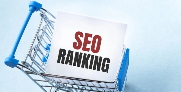 Alış veriş arabası ve SEO RANking 'i beyaz kâğıt üzerinde listelemek. Mavi arkaplanda alışveriş listesi kavramı.