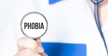 Doktor elinde PHOBIA yazılı steteskop tutuyor. Tıbbi konsept.