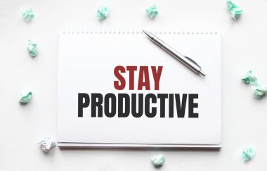 Boş çarşaf, kalem ve buruşuk kağıt toplar gri masada, düz yatıyordu. Metin Üretken Kal