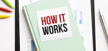 Beyaz büyük not defteri, yeşil kitap ve kâğıt üzerinde mali diyagram. Üzerinde 